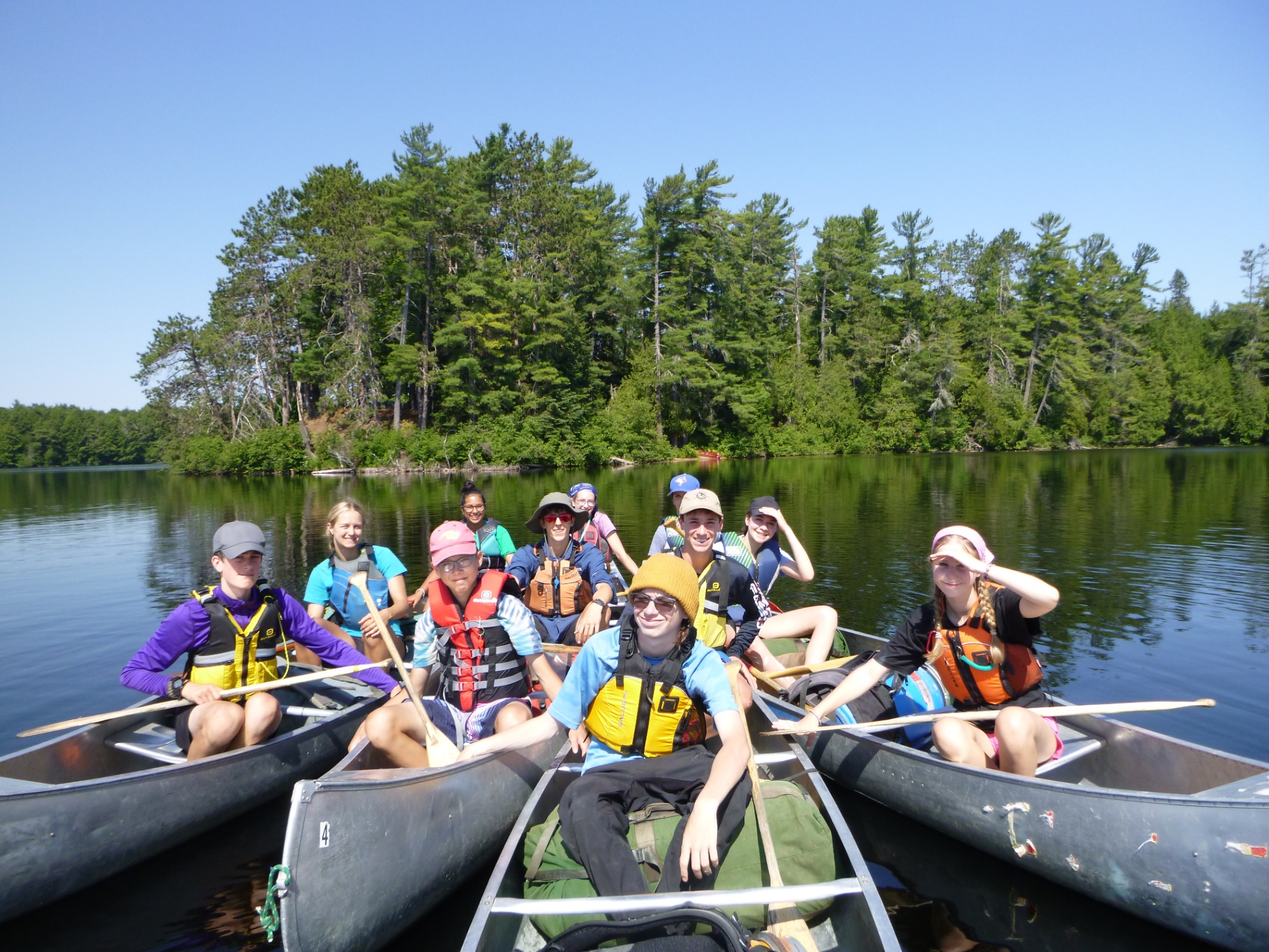 A group of students in canoes on a lake in a group